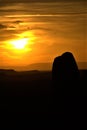 Vertical shpt of the silhouettes of rocks in Utah desert at sunset with yellow sky