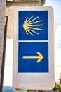 Vertical sign marking the direction to follow on the road to Santiago, with arrow and shell. Concept pilgrim, road, religion,