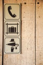 Vertical of signs for telephone, luggage claim, and personal objects in Firenze train station, Italy