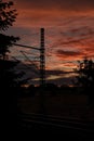 Vertical silhouette shot of powerlines on the side of a street during sunset Royalty Free Stock Photo