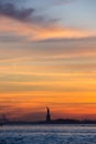 Vertical of the silhouette of statue of Liberty at sunset, red and yellow sky background