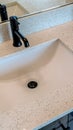 Vertical Single basin undermount sink with black faucet on white countertop over cabinet