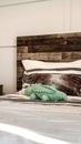 Vertical Single bed with brown wooden headboard and side table with modern lamp