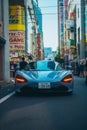 Vertical of a sleek blue car on the streets of Tokyo, Japan