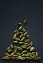 Vertical small DOF close up photo of Cardamom pods and seeds pile on the matt black background. It is very popular in Indian and Royalty Free Stock Photo