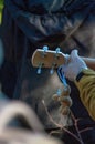 Vertical of a small teddy bear hanging from a headstock of a guitar in a man's hand Royalty Free Stock Photo