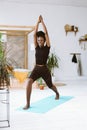 Vertical smiling, laughing dark skin multicultural woman practice yoga. Keep hands together in Virabhadrasana Warrior