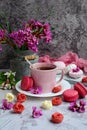 Vertical spring composition. A cup of tea, appetizing macarons, pink flowers and chocolate in the form of roses on a Royalty Free Stock Photo
