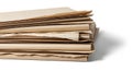 A stack of used brown paper sheets with frayed torn edges neatly folded and overlapping on a clean white background Royalty Free Stock Photo