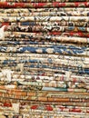 Vertical stack of colorful Middle Eastern style rugs and carpets
