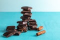 Vertical stacked slices of chocolate, cinnamon stick and star anise on turquoise background.