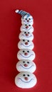 Multiple snowman heads stacked on a red background