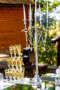 Vertical stand of champagne in the glasses. Candelstick with pearl thread. Nice tender decoration