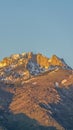 Vertical Striking mountain peak with rugged slopes against blue sky on a sunny day