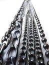 A vertical strip of shiny metal chains of various thicknesses extending into perspective on a white background