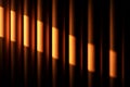 Vertical stripes of warm light and shadow create an abstract pattern with a dark background. Royalty Free Stock Photo
