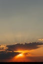 Vertical sunset shot with sun rays through thick clouds Royalty Free Stock Photo
