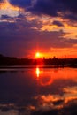 Vertical sunset on the water with symmetry of colorful clouds cumulonimbus Royalty Free Stock Photo
