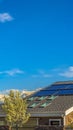 Vertical tall Roof with solar panels and skylights against lake and mountain under blue sky Royalty Free Stock Photo