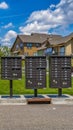 Vertical tall Row of cluster mailboxes with numbered compartments on the sidewalk