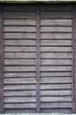 Vertical texture of a wall from several rows of brown old wooden boards. Painted wooden wall in brown colo Royalty Free Stock Photo