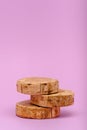 Vertical three wooden sawn podium on pink background, showcase concept