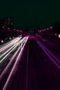Vertical timelapse shot of traffic lights on a street at night