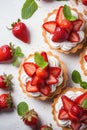 vertical top view closeup of delicious tartlets with fresh strawberry, bakery dessert with sweet berries and mint leaves on white Royalty Free Stock Photo