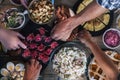 Vertical top view of friends eating together on a wooden table full of food - friendship and celenration people - concept of