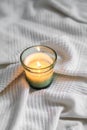 Vertical top view of a litten candle on a white comforter Royalty Free Stock Photo