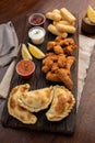 Vertical top view of a picada board with nuggets and tequenos with lemon slices and spicy sauces Royalty Free Stock Photo