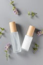 Vertical top view of skincare bottles on a surface with lavender flowers