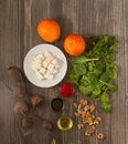 Vertical top view of a wooden table of ingredients for beet salad with oranges and feta cheese