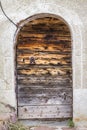 Vertical of a traditional old wooden arch door with a metallic handle Royalty Free Stock Photo