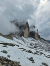 Vertical of Tre Cime di Lavaredo mountains surrounded by fog in Dolomites, Italy Royalty Free Stock Photo