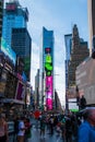 Vertical twilight view of crowded Times Square Broadway Avenue full of tourists