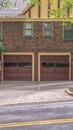 Vertical Two car garage with glass panes on door of a house with brick exterior wall