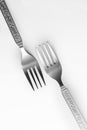 Vertical of two vintage engraved silverware forks isolated on a white background