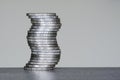 Vertical unstable curved pile of two euro coins on a grey background, future balance concept Royalty Free Stock Photo