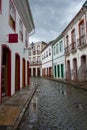 Vertical urban landscape with narrow street, colorful houses and cobbled pavements in Ouro Preto city, Minas Gerais - Brazil. Ouro Royalty Free Stock Photo