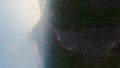 Vertical video. Aerial view tropical dark morning forest canyon frozen volcanic