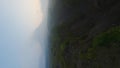 Vertical video. Tropical dirt road canyon frozen volcanic lava smoke eruption 4k