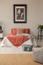 Vertical view of bedroom with king size bed with pillows, duvet and blanket and poster in frame on the wall Royalty Free Stock Photo