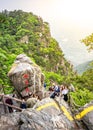 Vertical view of Chinese tourists posing next to a big rock in Lushan mountain national park in Mount Lu China