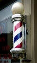 Vertical view of a classic Barber\'s pole with red, blue and white stripes