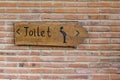 A vertical view of classic simple design handmade wooden sign of toilet give direction to WC , Bali, Indonesia. Close up Royalty Free Stock Photo