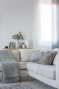 Corner sofa with pillows and blanket, copy space on empty white wall Royalty Free Stock Photo