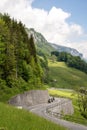 Vertical view of the curvy Klausenpass road in thw Swiss Alps high above the idyllic alpine village of Linthtal
