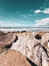 Vertical view of the Dinas Dinlle North Wales with crystal clear sea and big rocks on the shore