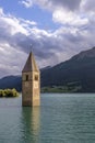 Vertical view of the famous bell tower of old Curon, submerged in the Resia lake, South Tyrol, Italy